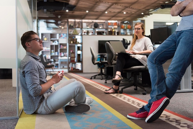 informele jongerengroep in moderne kantoren hebben teamvergaderingen en brainstormen terwijl ze aan het werk zijn