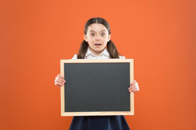 Informing kids changes in school life Check out responsibilities of pupils Topic of todays lesson School schedule information School girl pupil hold blackboard copy space School news concept