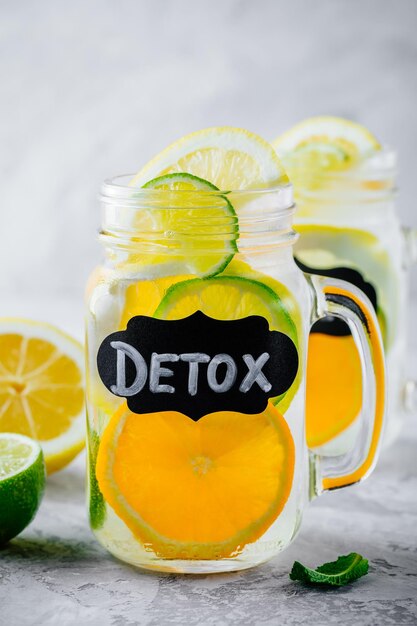 Infused detox water with orange lemon and lime refreshing citrus lemonade in glass mason jar