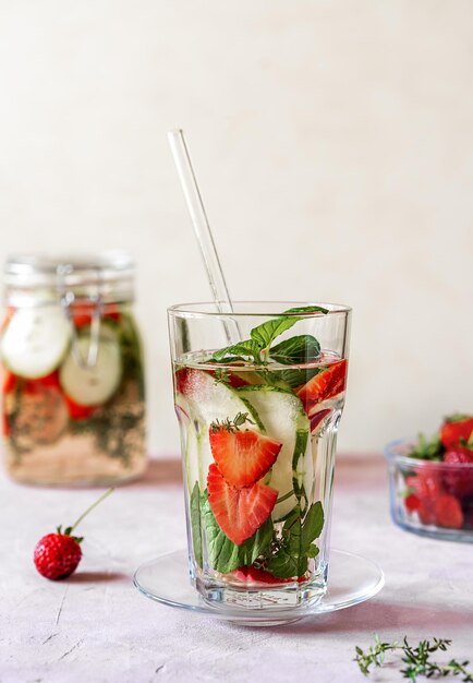 Infused water in glass jar with strawberry meloncella which is hybrid of cucumber herbs