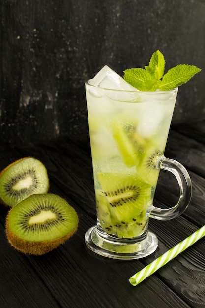 Infused water with kiwi, ice and  mint in the glass on the dark