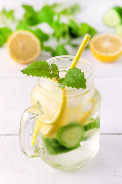 Настоянная вода с лимонным огурцом и мятой на деревянном фоне Detox Water Vertical Lemonad