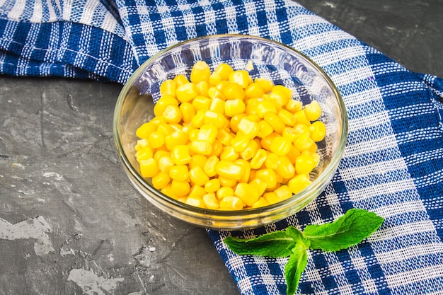 Ingeblikt graan in een glasplaat op een grijze concrete achtergrond.