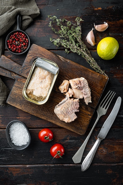 Ingeblikte wilde forel, op houten snijplank, op oude donkere houten tafel