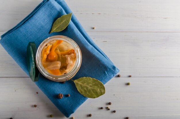 Ingemaakte champignons in een glazen pot op een witte achtergrond met kopieerruimte