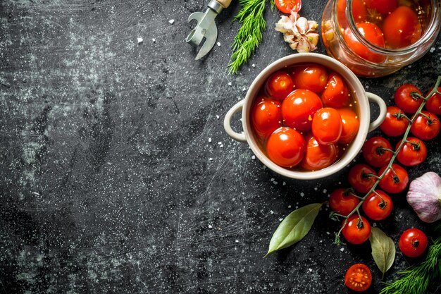 Ingemaakte tomaten in kom met dille en verse kerstomaatjes