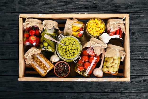 Ingemaakte voedingsmiddelen in blikken Voedselvoorraden Bovenaanzicht Op een houten achtergrond Kopieer de ruimte