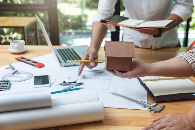 Ingenieur architects en makelaarskantoorteam die met blauwdrukken werken