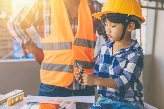 Ingenieur bouwer familie vaderdag rollenspel lesgeven zoon kind op de bouwplaats