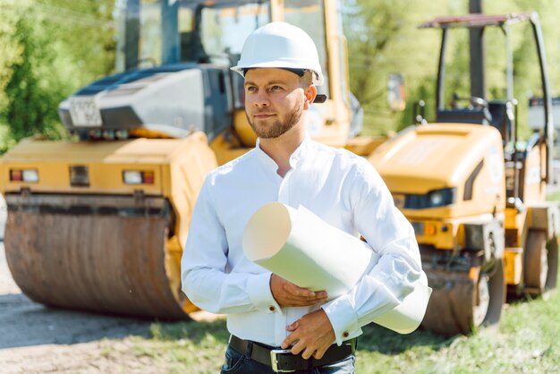 Ingenieur dichtbij wegenmachines. het concept van het bouwen van een nieuwe asfaltweg. reparatie van wegen. wegenwacht bij de ijsbaan.