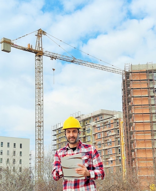 Foto ingenieur die de bouw van een onvoltooid gebouw controleert