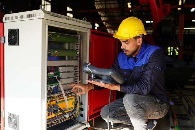 Ingenieur die het bedieningspaneel controleert en de nieuwe robotarm van Automatics en de bedieningsmachine in de fabriek leert