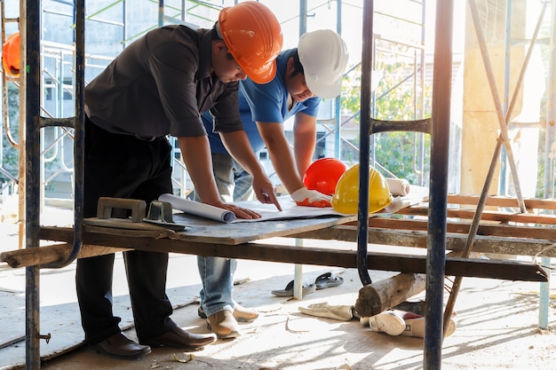 Ingenieur die met voorman over project in bouwconstructieplaats bespreken