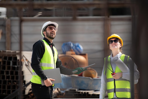 Ingenieur en architect die op de bouwplaats werken en plannen en processen dubbel controleren