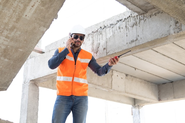 Ingenieur en architect werken bij bouwplaats met blauw opdruk.