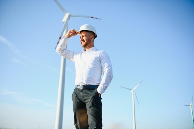 Ingenieur in tarweveld die de productie van turbines controleert