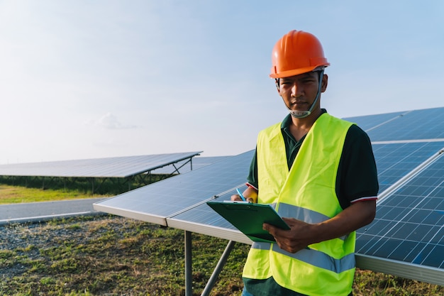 Foto ingenieur inspecteert zonnepaneel bij zonne-energiecentrale