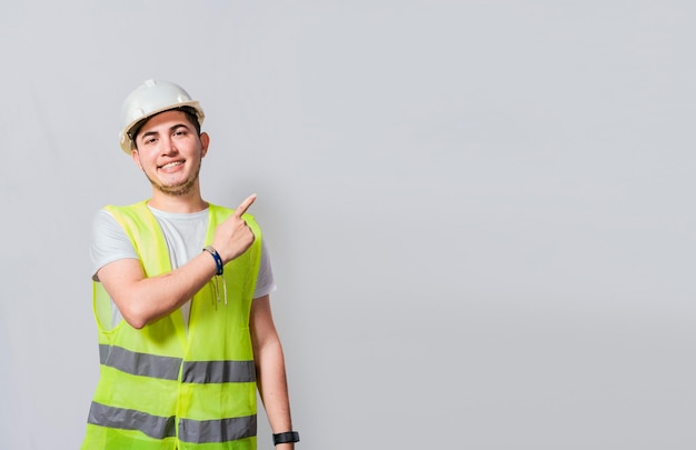 Ingenieur man wijzend naar kant Bouwer ingenieur wijzende vinger naar rechts geïsoleerd Portret van ingenieur man wijzend opzij Bouwkundig ingenieur met vest wijzend op een advertentie