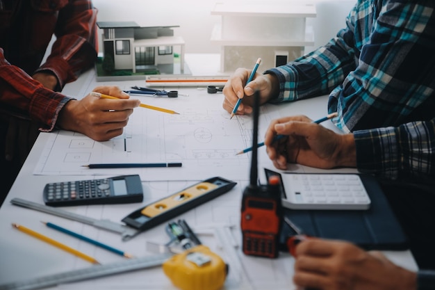 ingenieur mensen die werken en wijzen op een tekening in het kantoor voor het bespreken van engineering gereedschappen en bouwconcept