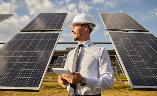 Ingenieur met behulp van tablet in veld met zonnepanelen