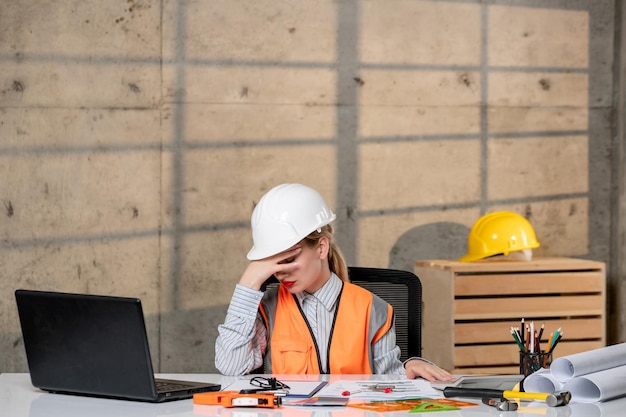 Foto ingenieur slimme jonge schattige blonde meisje civiele werknemer in helm en vest erg slaperig