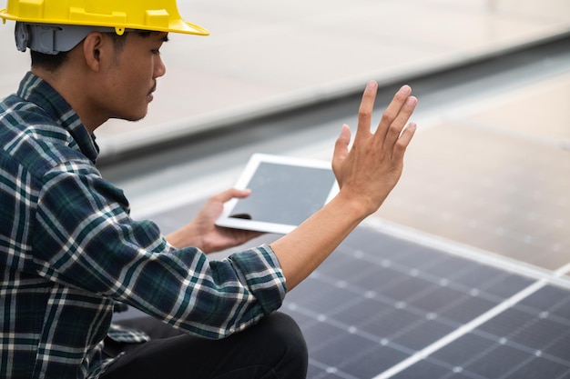 Ingenieur werknemer technologie zonnecel Aziatische ingenieur werkt aan fabriek op het dak die zonnecel-energiesysteem controleert voor project, vermindert het gebruik van elektriciteit in de fabriek