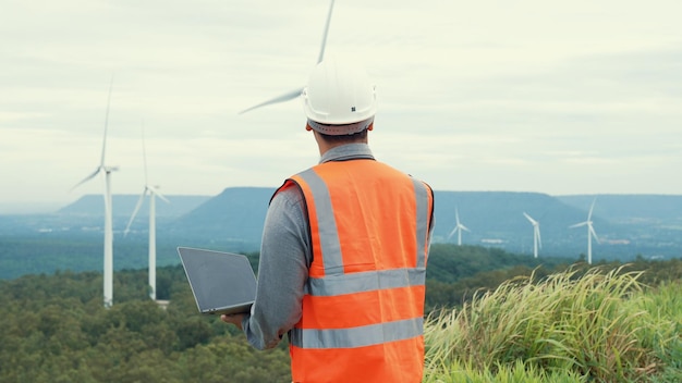 Ingenieur werkt aan een windpark bovenop een heuvel of berg op het platteland Progressief ideaal voor de toekomstige productie van hernieuwbare duurzame energie Energieopwekking uit windturbines