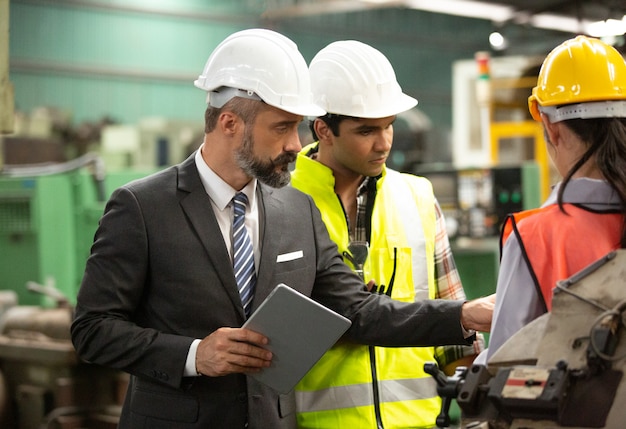 Foto ingenieurs die een machine in de fabriek bedienen