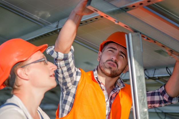 Ingenieurs die zonnepanelen op frame installeren.