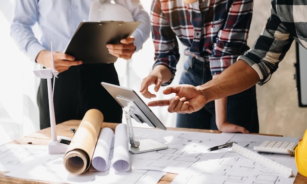 Ingenieursteams die samenkomen om samen te werken, dragen helmen van arbeidershelmen op de bouwplaats in het professionele team van de moderne stadsindustrie in officexA