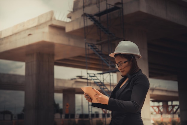 Foto ingenieursvrouw die bij plaats van brug in aanbouw werkt