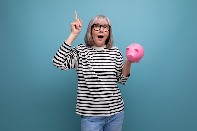 Ingenious grandmother middleaged woman has an idea where to invest her savings from a piggy bank on