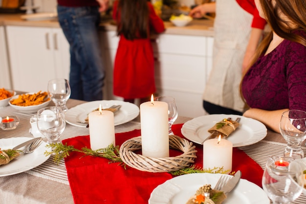 Ingerichte tafel met eten en kaarsen voor kerstavond. Familie samen koken met Kerstmis