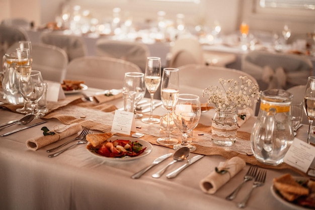 Ingerichte zaal voor huwelijksceremonie Bruiloft Banket De stoelen en ronde tafel voor gasten geserveerd met bestek bloemen