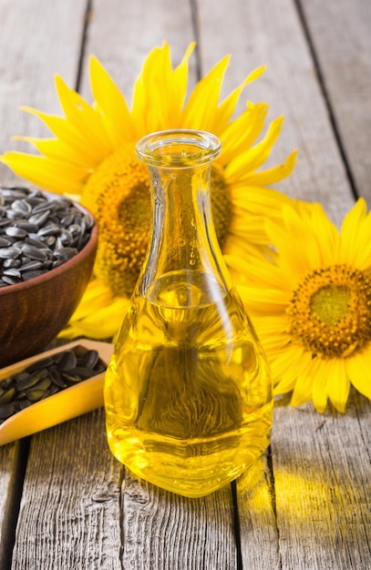 Ingredient oil seeds and sunflower on wooden background