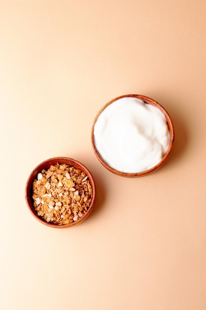 Ingrediënt voor ontbijt granola Griekse yoghurt op beige achtergrond bovenaanzicht