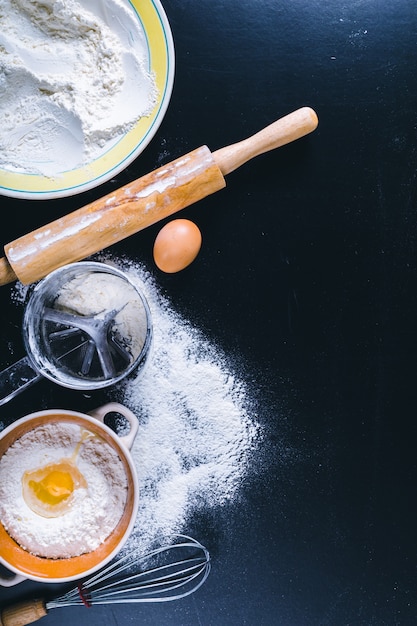 Ingrediënten en gebruiksvoorwerp voor het bakken op het zwarte bord, bovenaanzicht