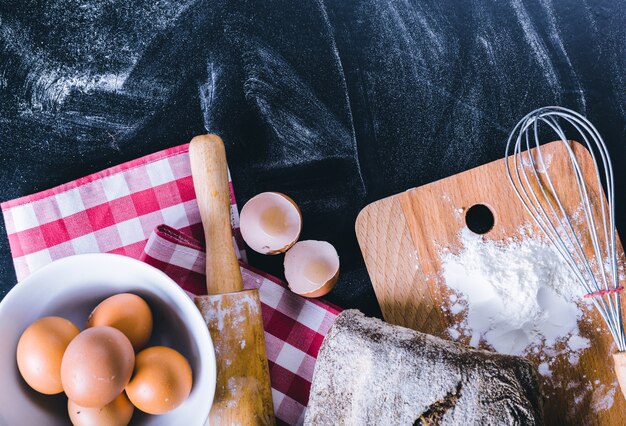 Ingrediënten en gebruiksvoorwerp voor het bakken op het zwarte bord, bovenaanzicht