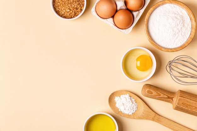 Ingrediënten en gebruiksvoorwerpen voor het bakken op een pastelkleurige achtergrond, bovenaanzicht.