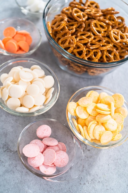 Ingrediënten in glazen mengkommen om Pasen-chocolade bedekte pretzelkonijntjes en eendjes te bereiden.