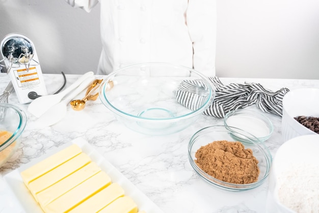 Ingrediënten mengen in een glazen mengkom om chocolate chip cookies te bakken.