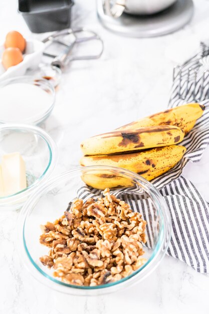 Ingrediënten mengen in keukenmixer om bananennotenbrood te bakken.