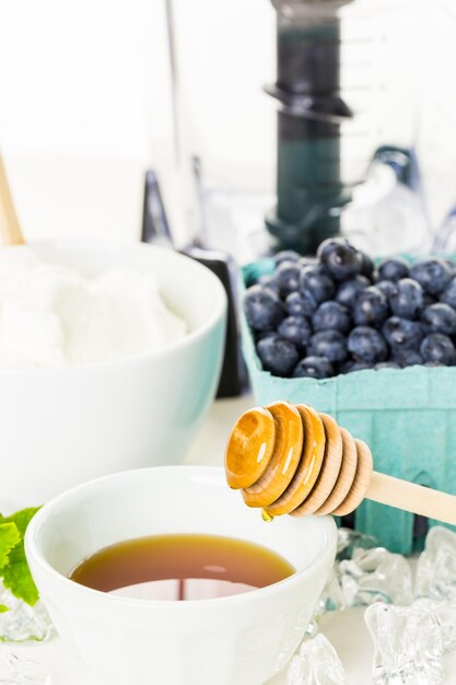 Ingrediënten om smoothie te maken met yoghurt en verse bessen op tafel.