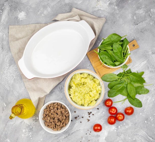 Foto ingrediënten voor braadpan aardappel vlees spinazie en tomaten