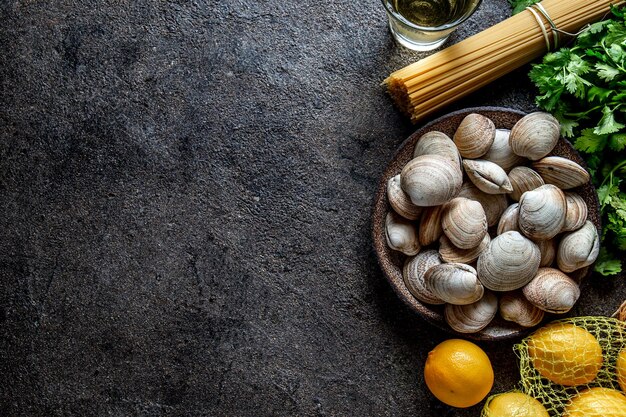 Ingrediënten voor de bereiding van spaghetti met schelpen rauwe verse schelpen spaghetti koriander witte wijn