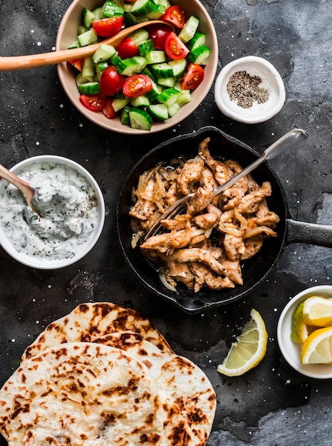 Ingrediënten voor griekse kip gyros gebakken kip tomaat komkommer salade tzatziki saus en flatbread