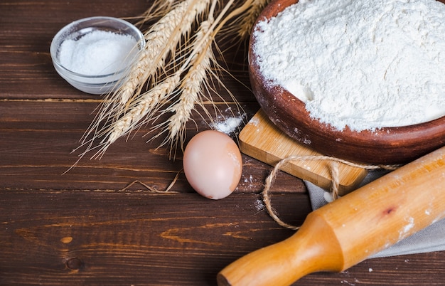 Ingrediënten voor het bakken op een houten tafel. Meel, eieren, tarwe, zout. Detailopname.