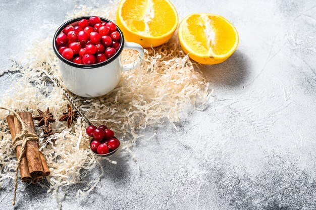 Ingrediënten voor het bakken van koekjes in de winter Peperkoek, fruitcake, dranken Veenbessen, sinaasappels, kaneel, specerijen Kerstmisvoedsel Grijs oppervlak