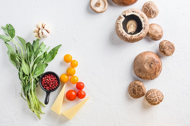 Ingrediënten voor het bakken van portobello, cheddarkaas, kerstomaatjes en salie