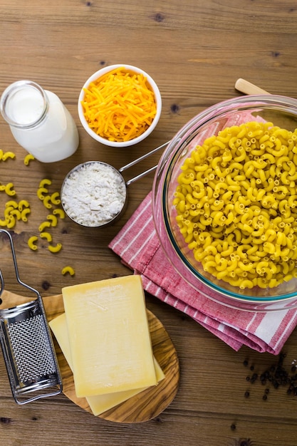 Ingrediënten voor het bereiden van macaroni en kaas op een houten tafel.